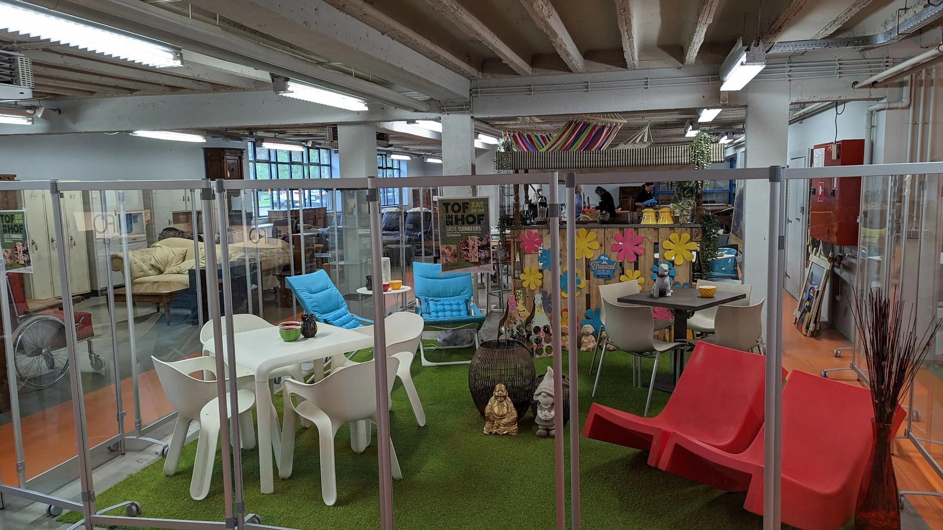 Overdekt winkelinterieur met glazen boxen, kunststofmeubels in fel kleuren en inrichtingsartikelen