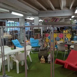 Overdekt winkelinterieur met glazen boxen, kunststofmeubels in fel kleuren en inrichtingsartikelen