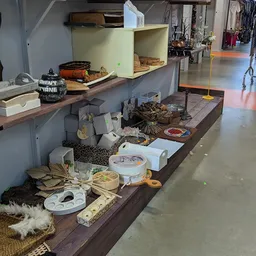 Verschillende tweedehands huishoudelijke spullen en decoratie op een bruine display tafel