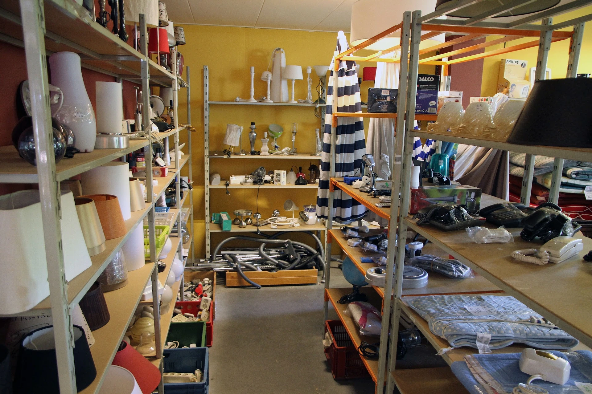 Winkelvloer met metalen stellingen vol huishoudartikelen, decoratie en textiel