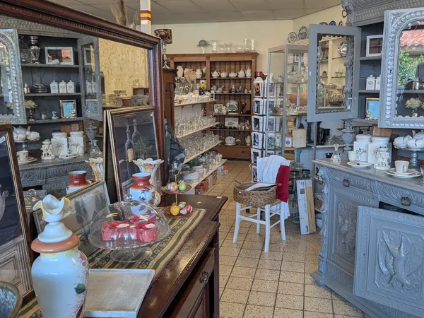 Winkelbinnenkant met houten vitrinekasten, stellages en diverse vintage spullen en decoraties uitgestald