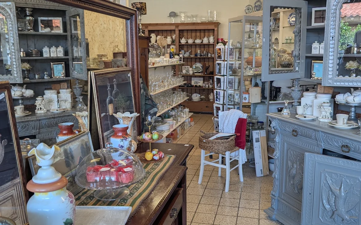 Winkelbinnenkant met houten vitrinekasten, stellages en diverse vintage spullen en decoraties uitgestald