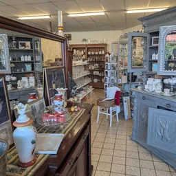 Winkelbinnenkant met houten vitrinekasten, stellages en diverse vintage spullen en decoraties uitgestald