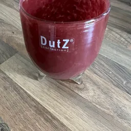 Rode glazen pot met DutZ-merk erop, op een houten ondergrond