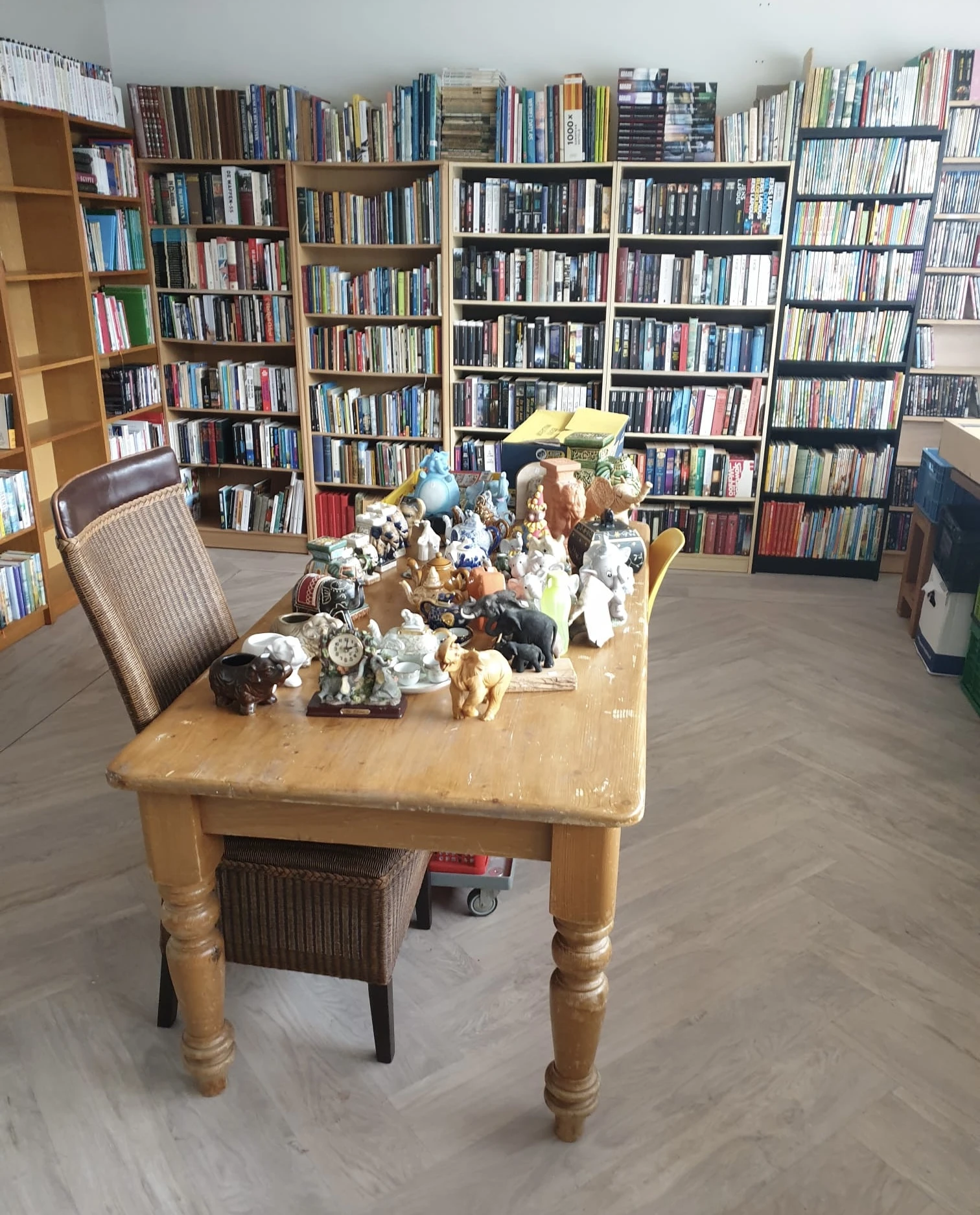 Houten tafel vol met verzameling decoratieve beeldjes, figuurtjes en voorwerpen uit tweedehands assortiment