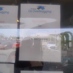 Schermafbeelding van een website met vergrote weergave van een parkeerterrein en winkelgebouw