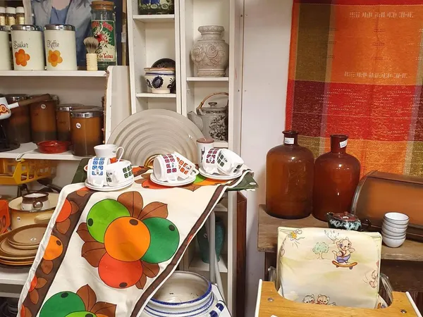 Uitgestalde serviesgoed, glazen en decoratieve items in een kringloopwinkel