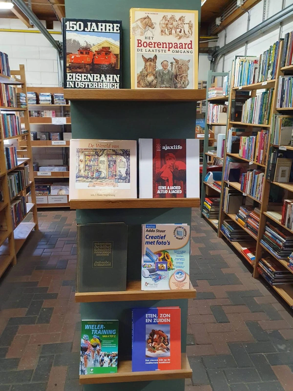 Boekenrek met uitgestalde boeken en kunstboeken in een kringloopwinkel