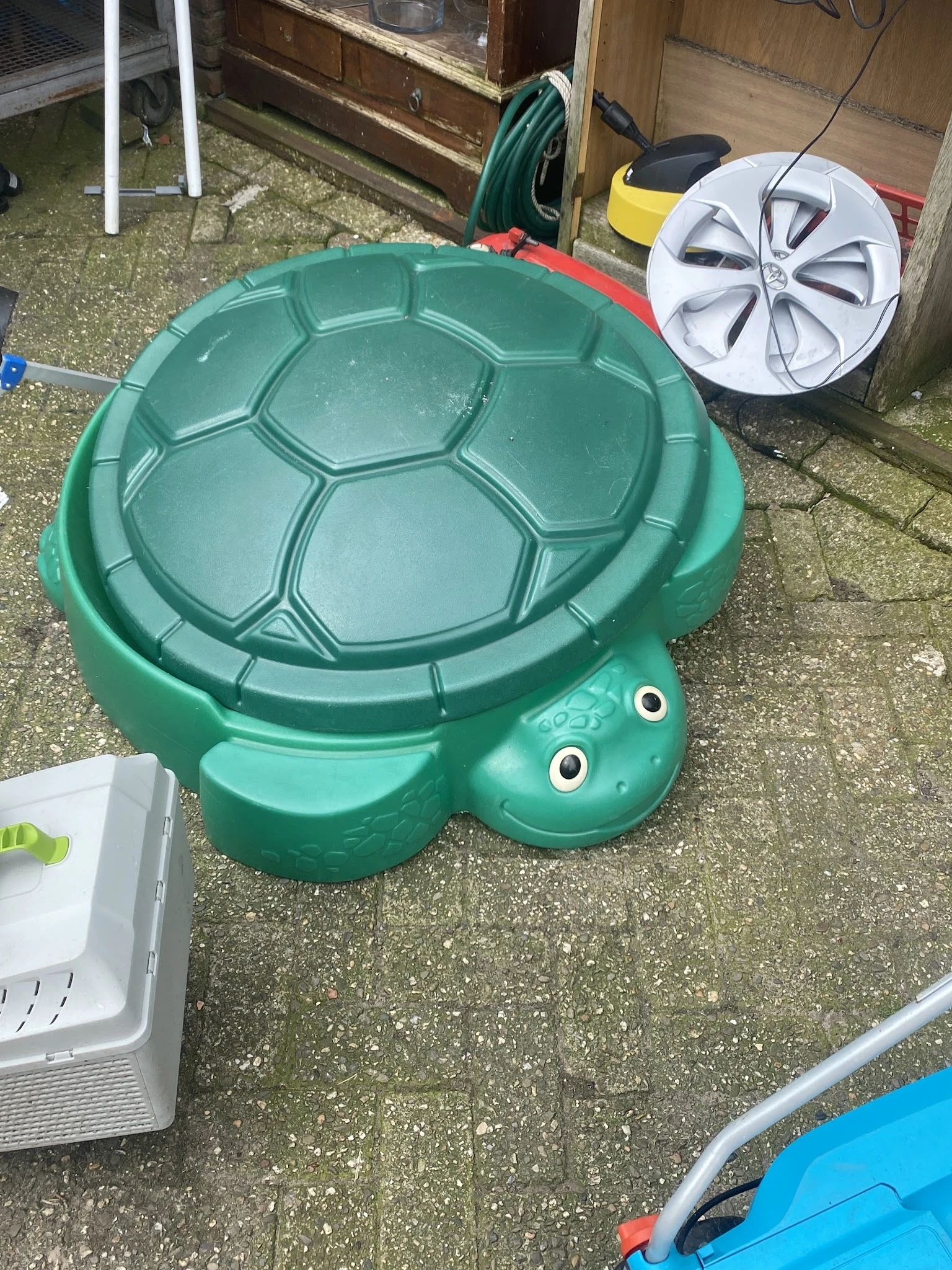 Groene kunststof schildpadzandkasteel met dekselvormige rug en twee ogen
