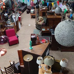 Winkelvloer van kringloopwinkel met meubels, lampen, servies en diverse huishoudelijke artikelen