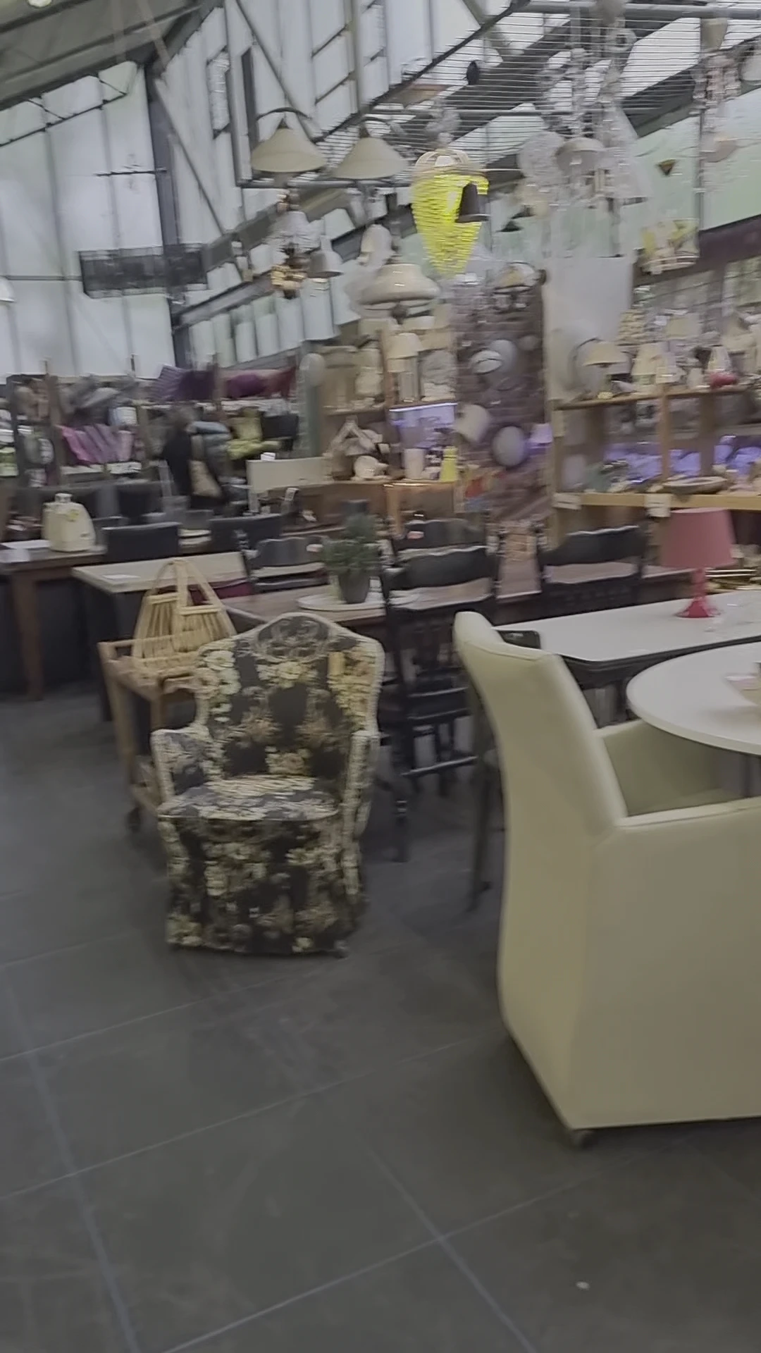Winkelvloer met diverse meubels, tafels en stoelen in een kringloopwinkel
