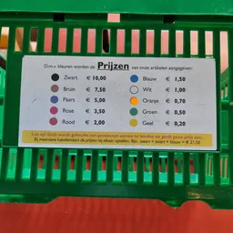 Prijzenbord voor kleuren in een kringloopwinkel met prijzen van €0,20 tot €10,00