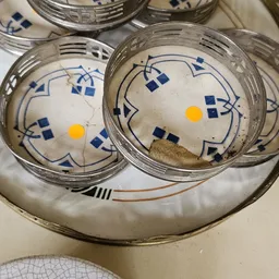 Twee glazen schaaltjes met blauw-wit decoratief patroon en gele knop in het midden