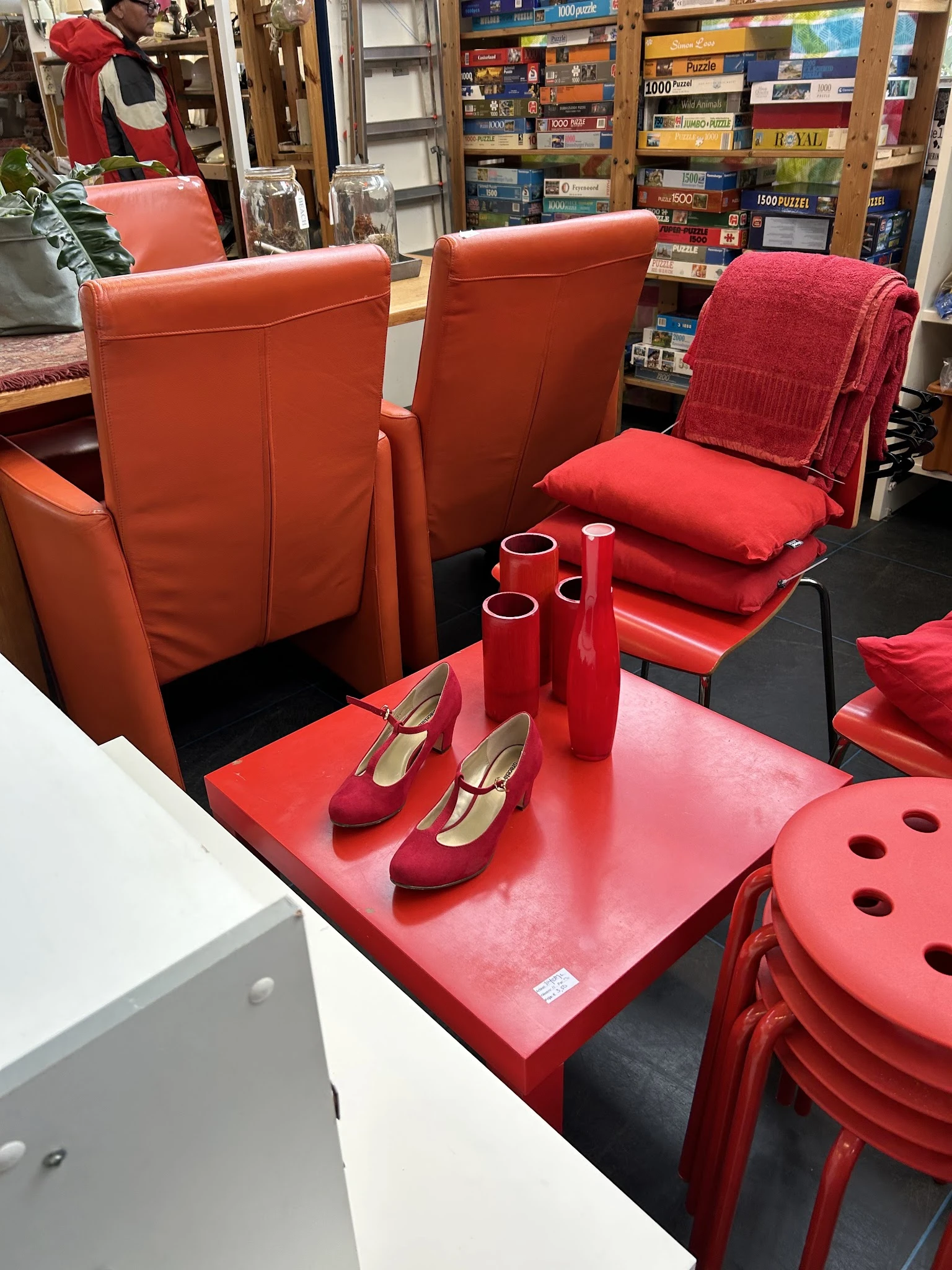 Uitgestalde dames-schoenen en rode accessoires op een rode tafel in de winkel