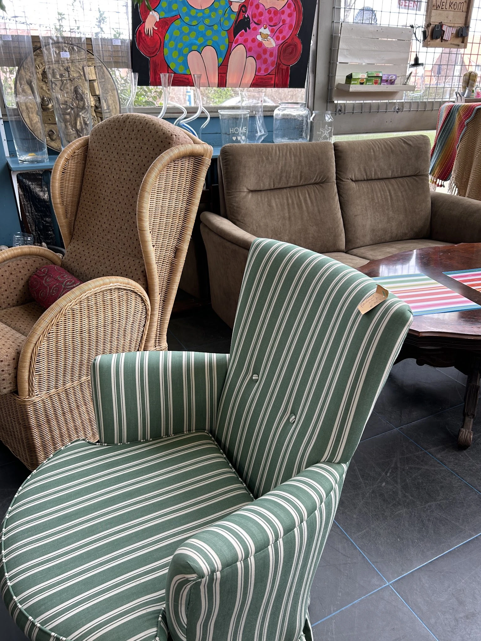 Fauteuils en stoelen met groen-wit gestreepte bekleding en rieten stoelen in uitstalling