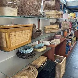 Schappen met diverse rieten manden, houten kratten en huishoudelijke accessoires