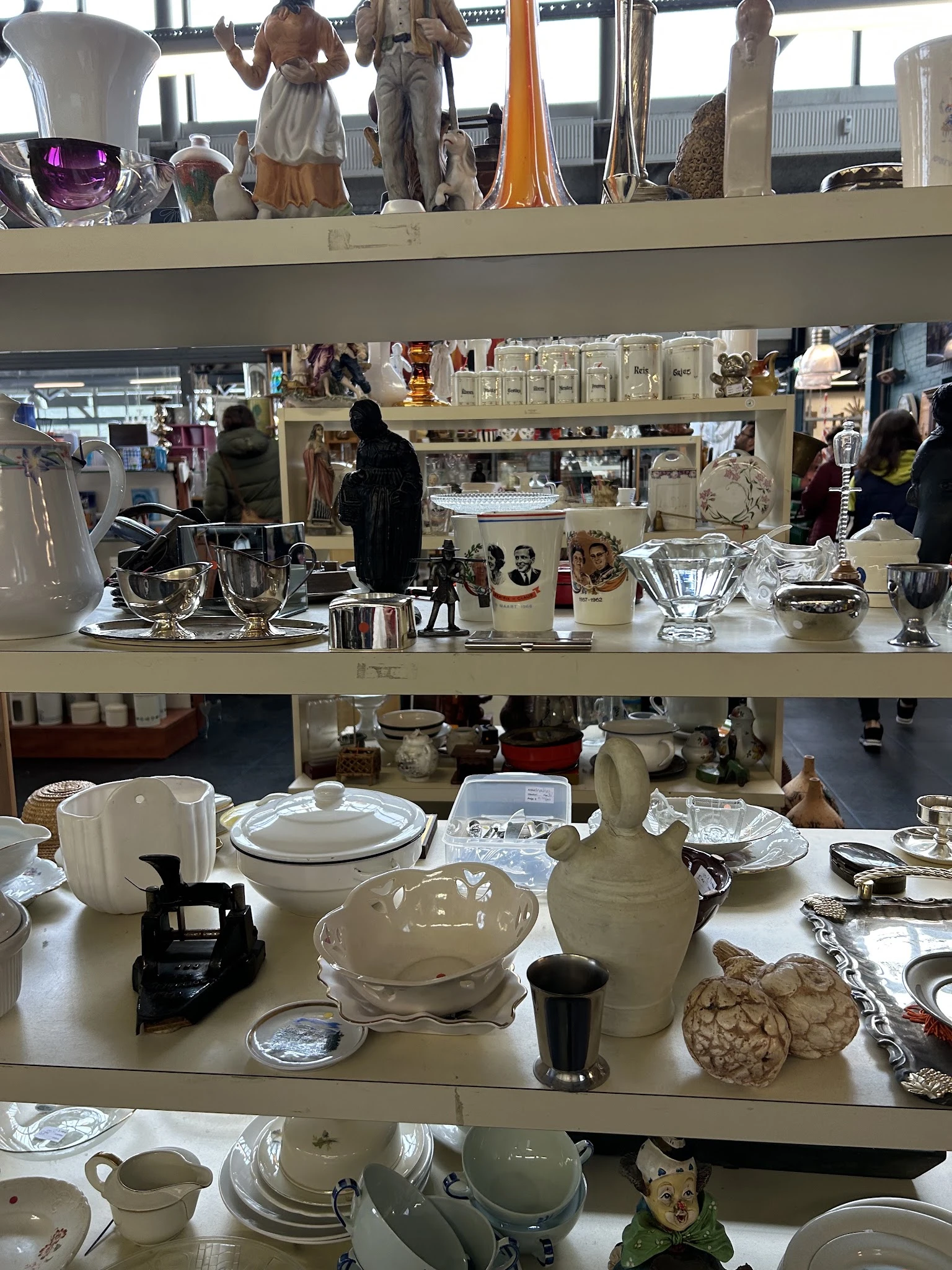 Tweedehands serviesgoed, kopjes, schalen en glazen op uitstalling in de winkel