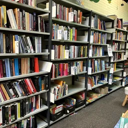 Boekenkasten vol met tweedehands boeken in verschillende genres en kleuren