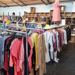 Winkelvloer met kledingrekken en houten kastjes met tweedehands kleding en spullen
