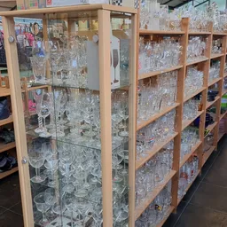Houten kasten en stellingen vol met kristalglazen en drinkglazen in diverse vormen en maten