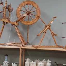 Houten spinwielen, spinnewiel en ander antiek huishoudelijk gereedschap op een houten stellage