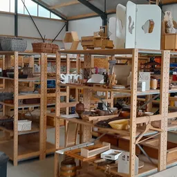 Winkelvloer met houten stellingen vol met huishoudelijke artikelen, servies en diverse spullen in een kringloopwinkel