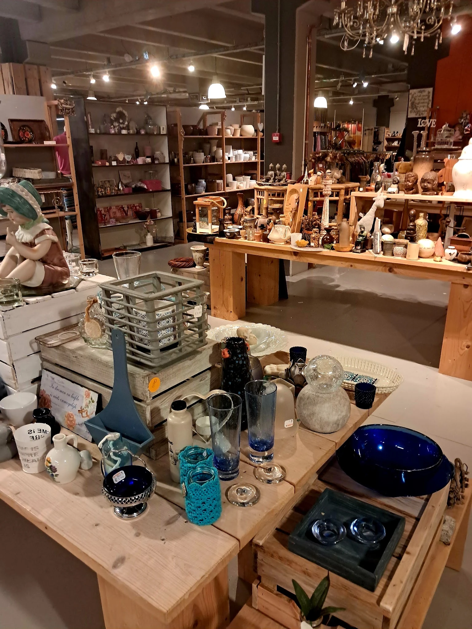 Tafel met diverse huishoudartikelen: glazen, karaffen, kandelaren en andere decoratieve items
