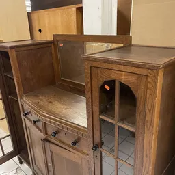 Houten vintage meubels met glazen deuren en laden, waaronder een kastje met rasterpatroon