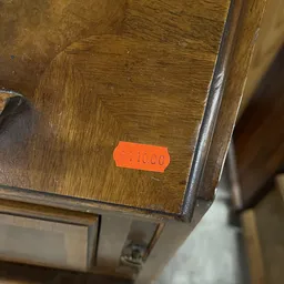 Oranje prijssticker met nummer op houten meubel