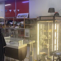 Verlichte vitrinekasten met serviesgoed en huishoudelijke artikelen in de kringloopwinkel