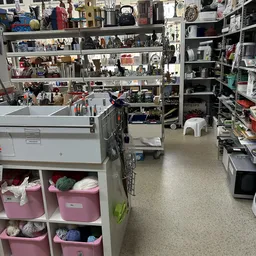 Winkelvloer met stellingen, rekken en dozen in een kringloopwinkel