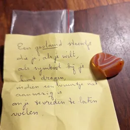 Handgeschreven gele notitie met Nederlands tekst en een rood hartje ernaast