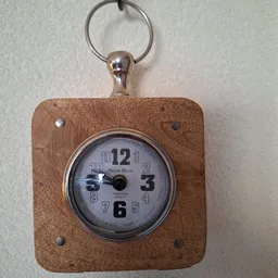 Houten wandklok met Notre Dame opschrift en zilveren behuizing, hangend aan een ketting