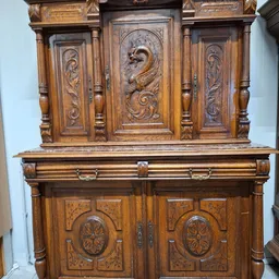 Antieke houten kast met gesneden decoraties en koperen handgrepen