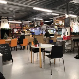 Koffiehoek met tafels, stoelen en toonbank in kringloopwinkel