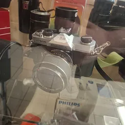 Vintage Fujica camera met lens op display, naast een Philips doos