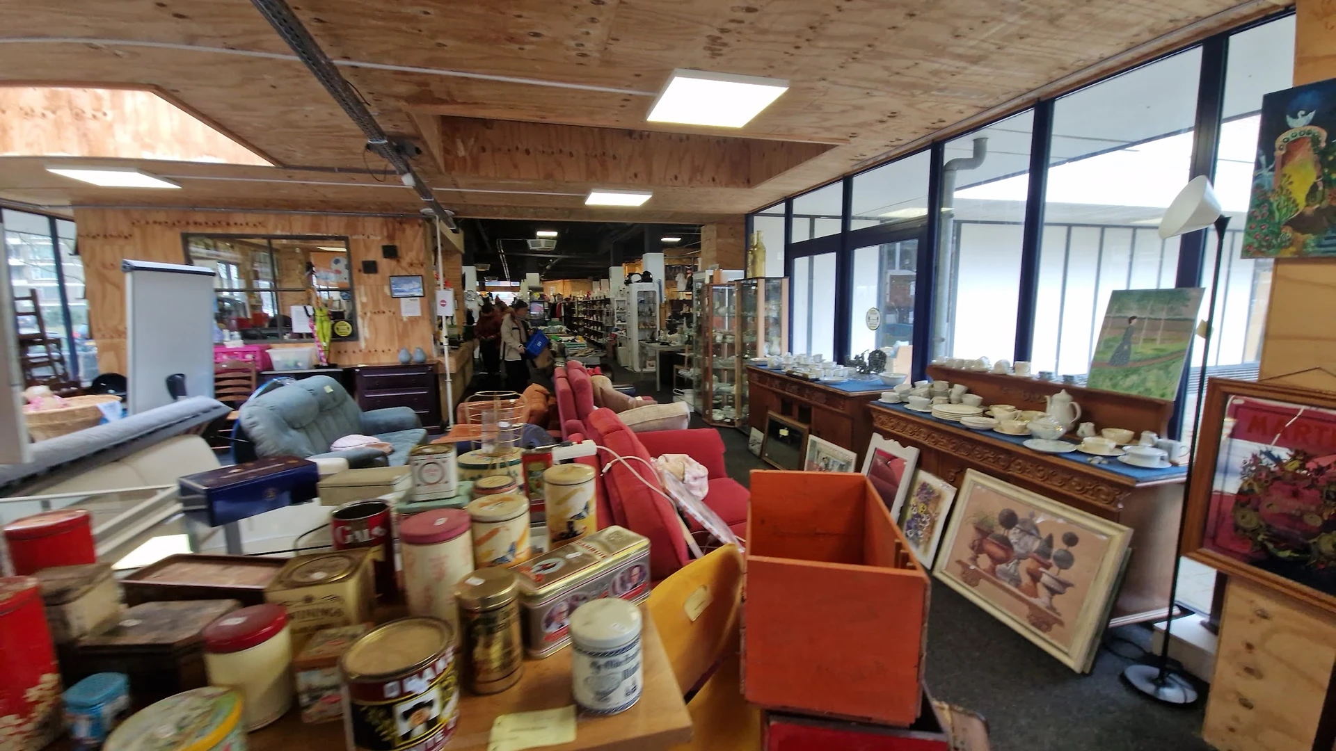 Winkelvloer met dozen, rekken en uitgestalde spullen in een kringloopwinkel