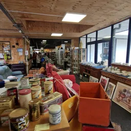 Winkelvloer met dozen, rekken en uitgestalde spullen in een kringloopwinkel