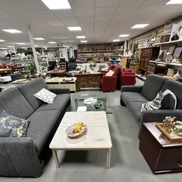 Winkelvloer met grijze en rode fauteuils, tafels en houten meubels
