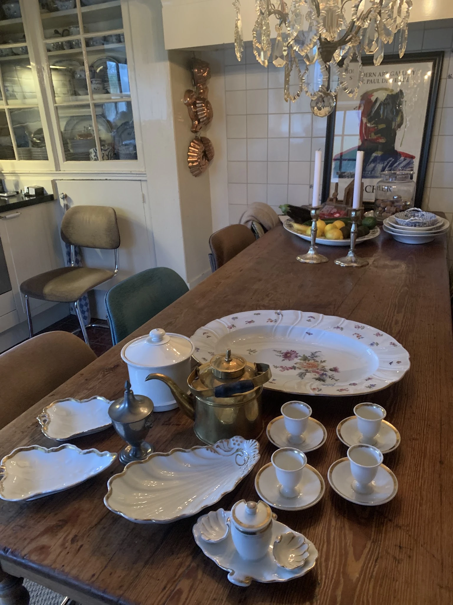 Servies en theepot op houten tafel: borden, kopjes, kannen en decoratieve schalen met bloemmotieven