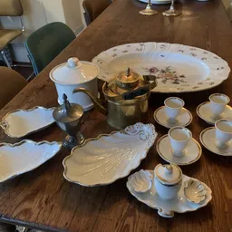 Vintage serviesset met theepot, koffiekan, borden en kopjes op houten tafel