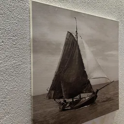 Sepia zwart-wit foto van een zeilboot met donkere zeil op zee