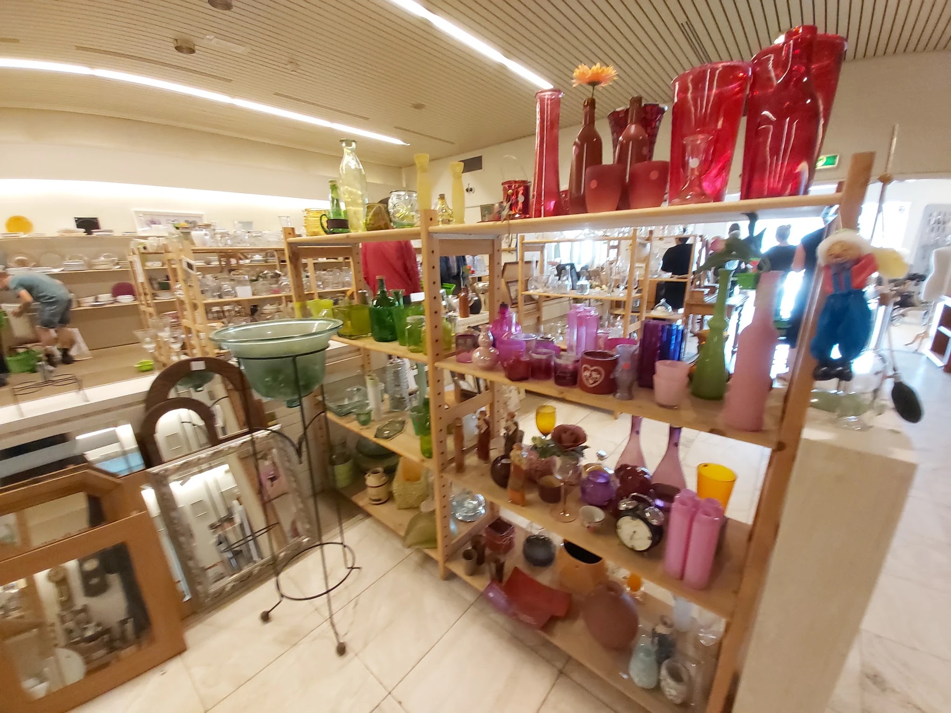 Houten stellingen met diverse huishoudartikelen en decoratie in paars, rood en roze