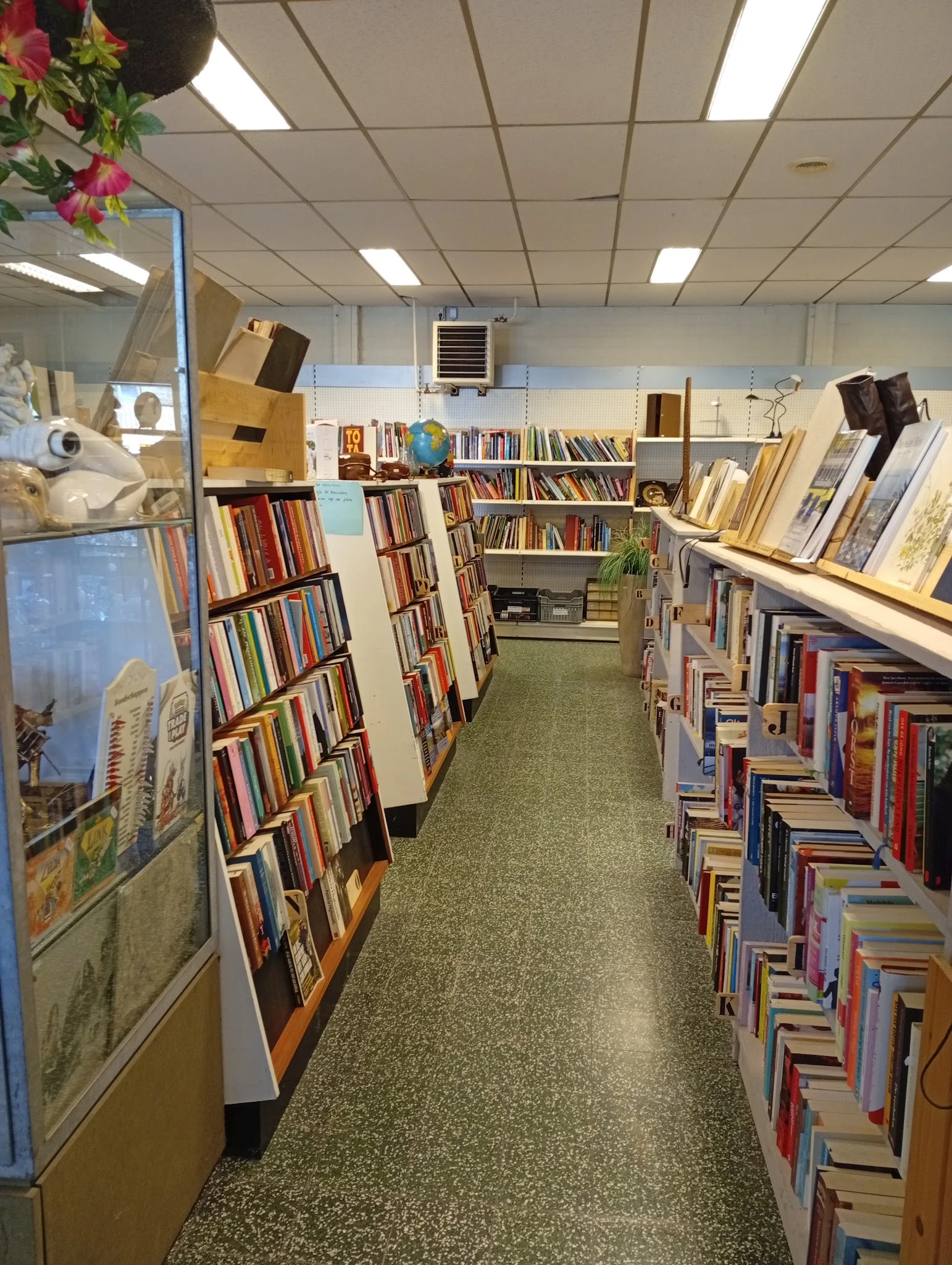 Boekenrekken langs de wanden van een kringloopwinkel met diverse tweedehands boeken
