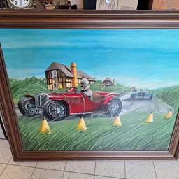 Geschilderd kunstwerk in houten lijst met vintage rode sportwagen op landelijk landschap