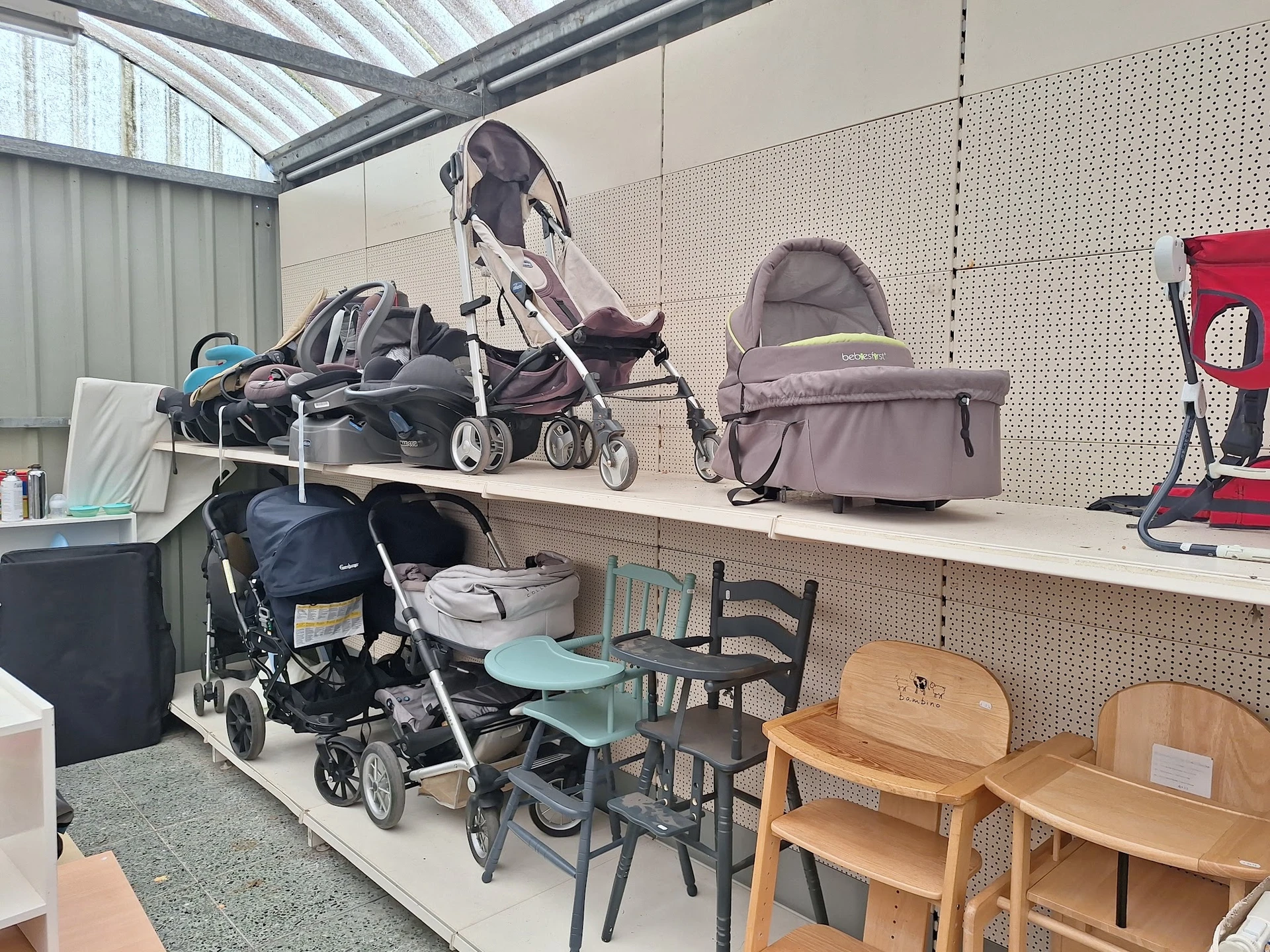 Uitstallingen met kinderartikelen: kinderwagens, buggy's, stoelen en andere babygoederen in de kringloopwinkel