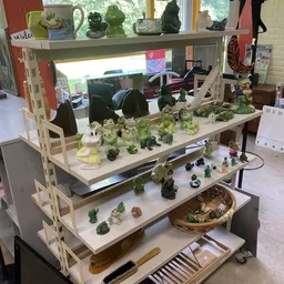 Stellingkast met verzameling groene porseleinen dieren en decoratiefiguren uitgestald op meerdere niveaus
