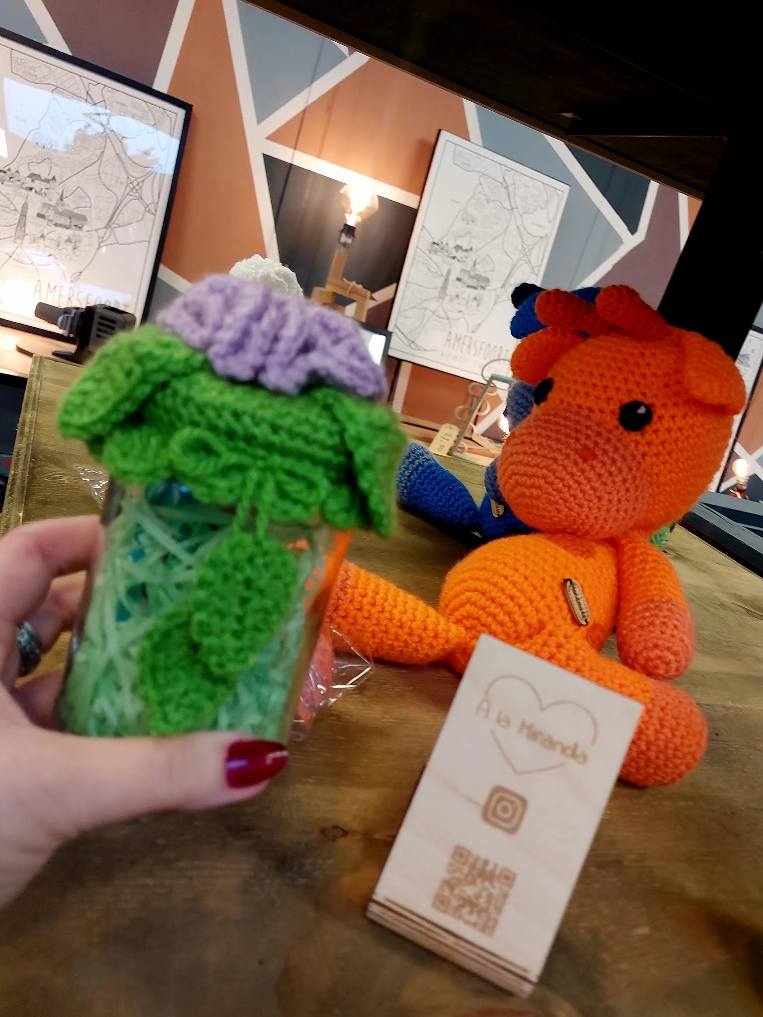 Close-up van twee gebreide knuffels: een groen monster met paars haar en een oranje dier met blauwe accenten