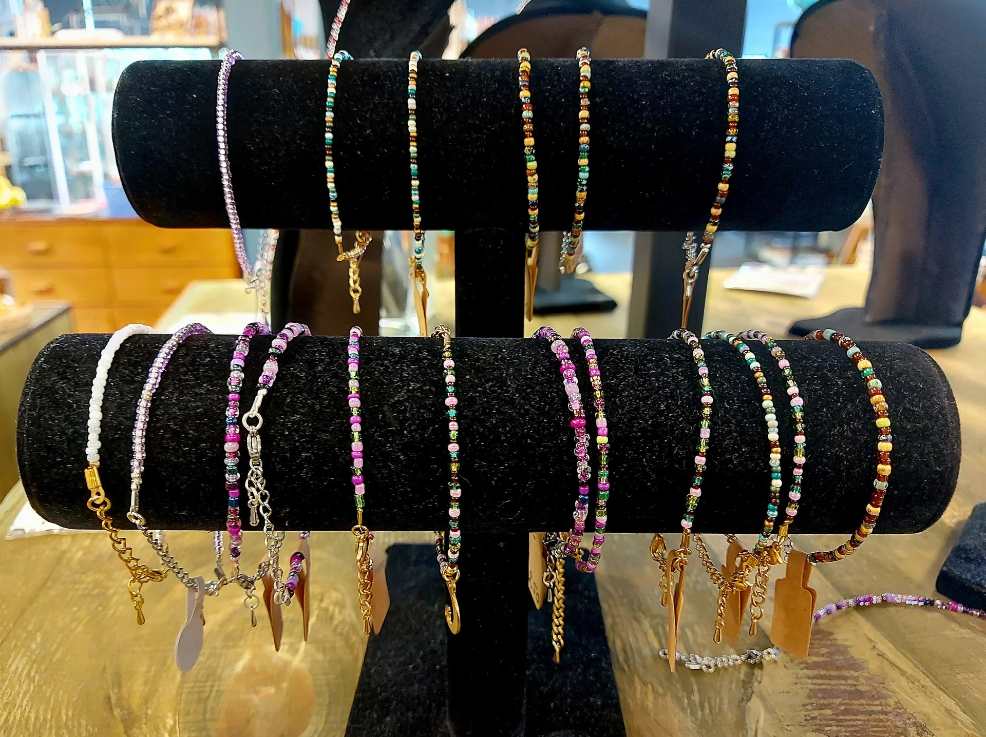 Uitgestalde armbanden met kralen en metalen details op zwarte displaystandaards