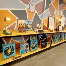 Uitgestalde vintage artikelen op gele planken tegen kleurrijke geometrische muurachtergrond